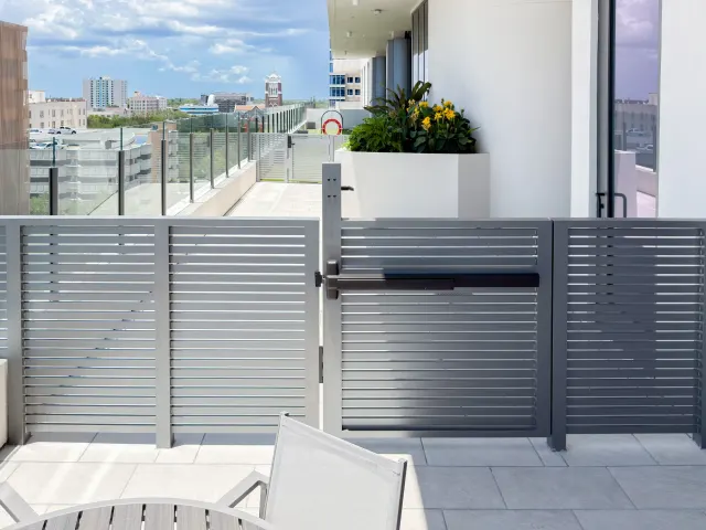 Louvered privacy screens and gate on an Art House terrace.