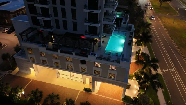 The lit rooftop pool at Hyde Park House after dark, ringed with Poma glass railing.